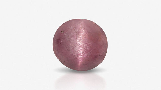 Figure 1. This 0.50 ct purplish pink cabochon is a rare chatoyant example of hexagonite. Photo by Jian Xin (Jae) Liao. Figure 1. This 0.50 ct purplish pink cabochon is a rare chatoyant example of hexagonite. Photo by Jian Xin (Jae) Liao.