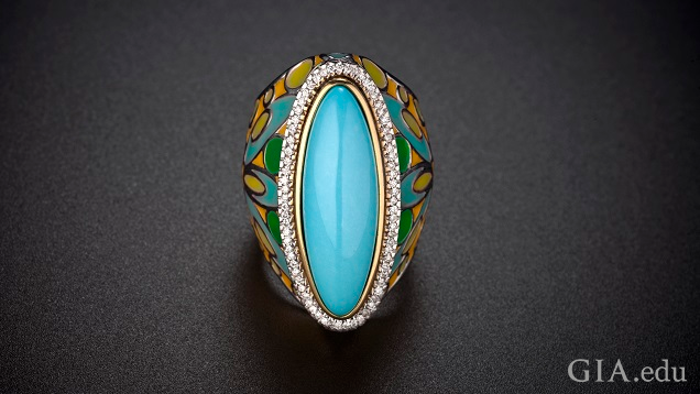 An elongated oval piece of turquoise is framed by diamonds with a enameled shank of turquoise, green, yellow and orange colors. An elongated oval piece of turquoise is framed by diamonds with a enameled shank of turquoise, green, yellow and orange colors.