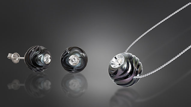 Figure 5. The Diamond in a Pearl collection, Huynh’s first, is designed to illustrate a pearl’s formation and symbolizes how true love can survive hardship. This jewelry set, named “Rhythm of Life,” features a combination of pearl carving and Diamond in a Pearl techniques. The pendant contains a 12 mm carved Tahitian pearl, and each earring contains a 10 mm carved Tahitian pearl. The whole set is mounted with 14K white gold. Courtesy of Chi Huynh. Figure 5. The Diamond in a Pearl collection, Huynh’s first, is designed to illustrate a pearl’s formation and symbolizes how true love can survive hardship. This jewelry set, named “Rhythm of Life,” features a combination of pearl carving and Diamond in a Pearl techniques. The pendant contains a 12 mm carved Tahitian pearl, and each earring contains a 10 mm carved Tahitian pearl. The whole set is mounted with 14K white gold. Courtesy of Chi Huynh.