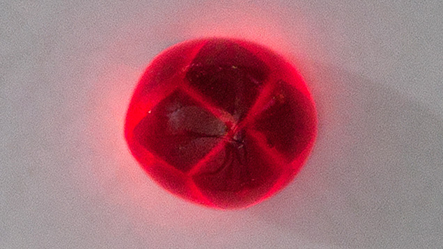 Figure 2. This 3.57 ct garnet emits vivid red through the trapiche patterns when shining a flashlight through the gem. Photo by Le Ngoc Nang. Figure 2. This 3.57 ct garnet emits vivid red through the trapiche patterns when shining a flashlight through the gem. Photo by Le Ngoc Nang.