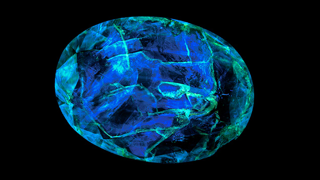 Figure 13. The epoxy filling of this clarity-enhanced emerald fluoresces blue under 365 nm illumination. From Tsai (2021). Figure 13. The epoxy filling of this clarity-enhanced emerald fluoresces blue under 365 nm illumination. From Tsai (2021).