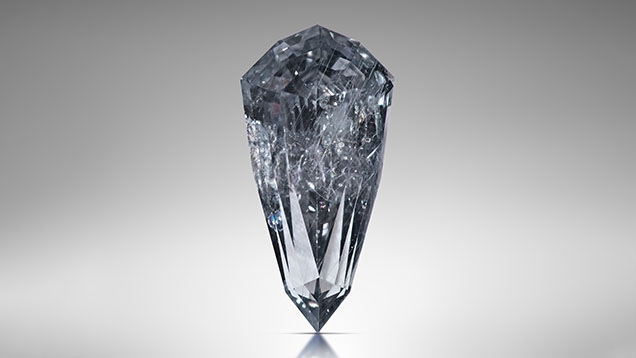 Figure 2. This 3.49 ct sapphire (sample RK-FBS 030) measuring 13.23 mm long was faceted from an 11.15 ct rough crystal in basaltic trachyandesite matrix recovered from the French Bar sill. A combination of diffused daylight-equivalent (6500 K) LED monolights from the front and a narrow beam of light from behind accentuate both the Rose channel inclusions and the bodycolor. Photo by Jeff Mason. Figure 2. This 3.49 ct sapphire (sample RK-FBS 030) measuring 13.23 mm long was faceted from an 11.15 ct rough crystal in basaltic trachyandesite matrix recovered from the French Bar sill. A combination of diffused daylight-equivalent (6500 K) LED monolights from the front and a narrow beam of light from behind accentuate both the Rose channel inclusions and the bodycolor. Photo by Jeff Mason.