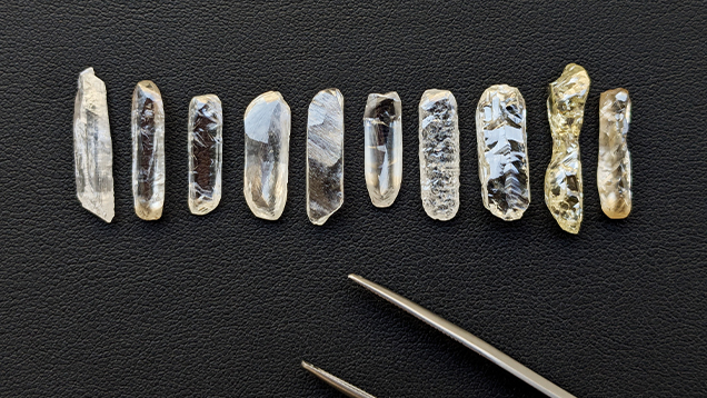10 pale yellow baguette shaped rough diamonds against a black surface 10 pale yellow baguette shaped rough diamonds against a black surface