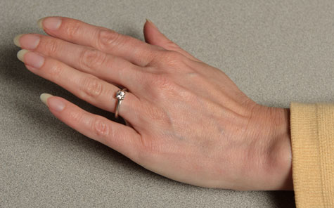 Female hand featuring a properly fitted platinum solitaire Female hand featuring a properly fitted platinum solitaire