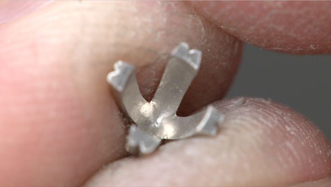 Jeweler holding the setting of a four-prong, platinum solitaire with no center stone. The inside of the setting is visible. Jeweler holding the setting of a four-prong, platinum solitaire with no center stone. The inside of the setting is visible.