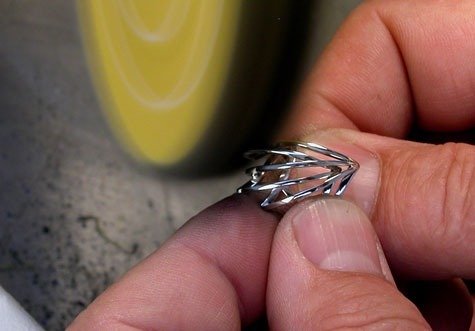 Jeweler polishing a platinum ring at a polishing machine. Jeweler polishing a platinum ring at a polishing machine.