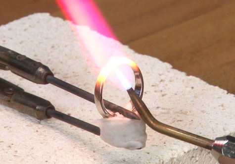 Hold the platinum ring with tungsten carbide- or platinum-tipped tweezers. Place a few layers of tissue between the tweezers and the ring to prevent scratches. Hold the platinum ring with tungsten carbide- or platinum-tipped tweezers. Place a few layers of tissue between the tweezers and the ring to prevent scratches.