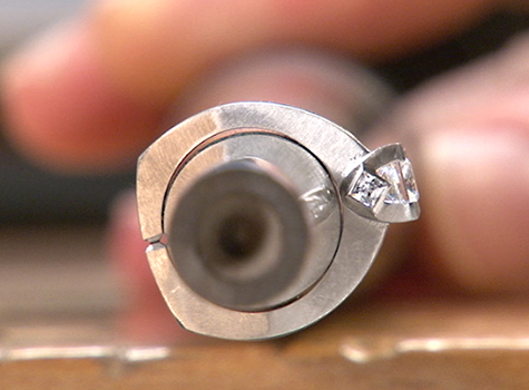 Side view of a platinum solitaire ring on a ring mandrel where gaps around the ring indicate that the ring is out of round. Side view of a platinum solitaire ring on a ring mandrel where gaps around the ring indicate that the ring is out of round.