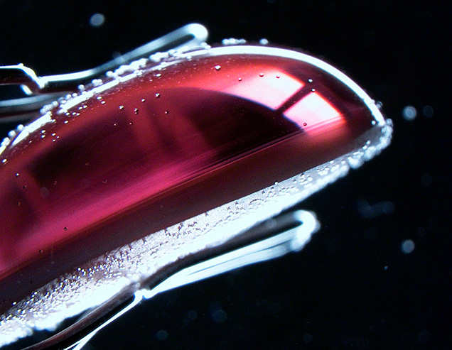 Side view of alexandrite cabochon showing inclusions near base. Side view of alexandrite cabochon showing inclusions near base.