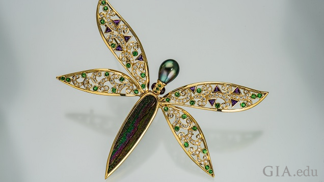 Dragon fly pin with drusy body and pearl head; wings are set with clear and green gems. Dragon fly pin with drusy body and pearl head; wings are set with clear and green gems.