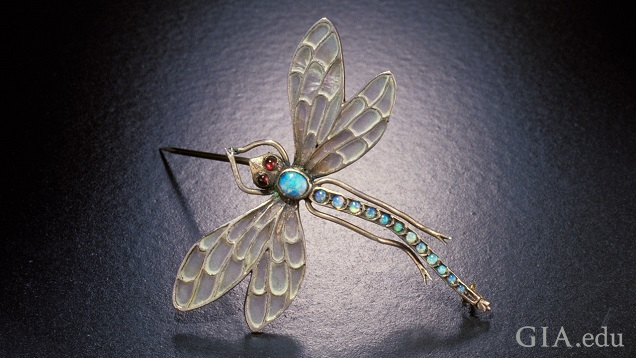 View of a dragonfly brooch from above. Translucent wings and body of blueish opal. View of a dragonfly brooch from above. Translucent wings and body of blueish opal.