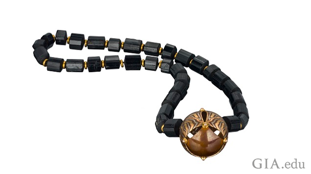A mokume gane bead on a black gemstone necklace. A mokume gane bead on a black gemstone necklace.